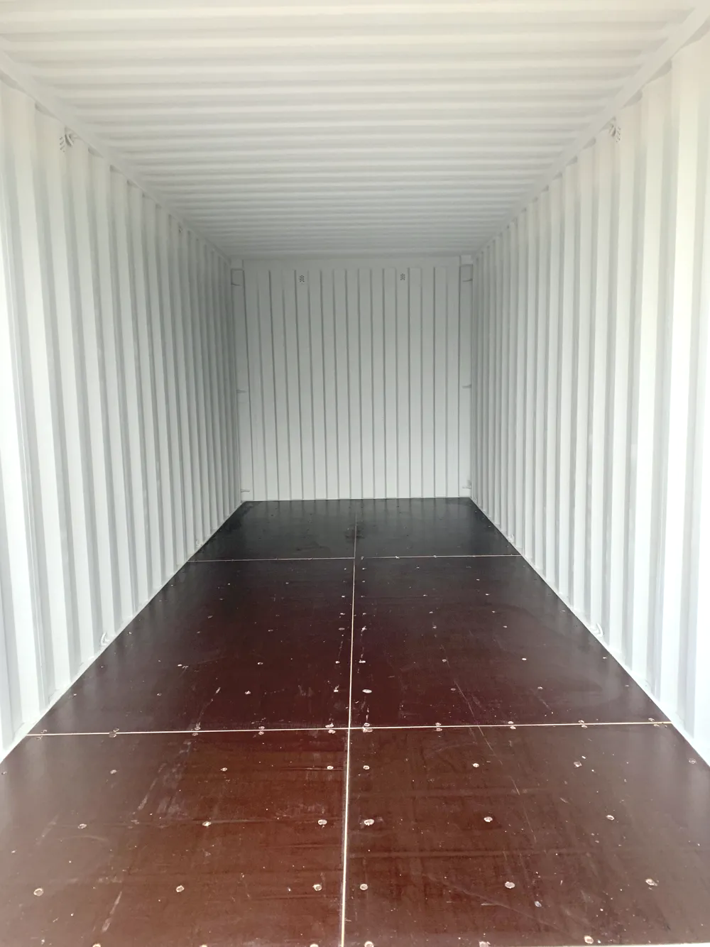 The bright, clean inside of a storage container with a swept timber floor