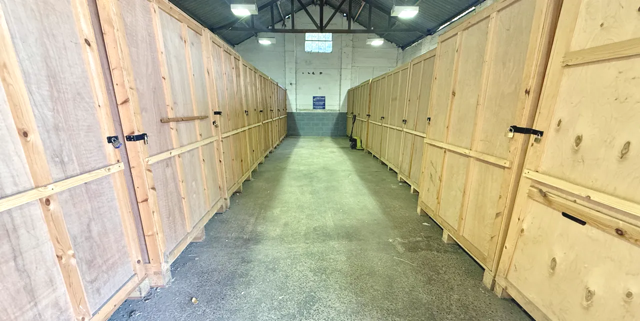 A row of large wooden storage crates inside Perry Storage's covered warehouse